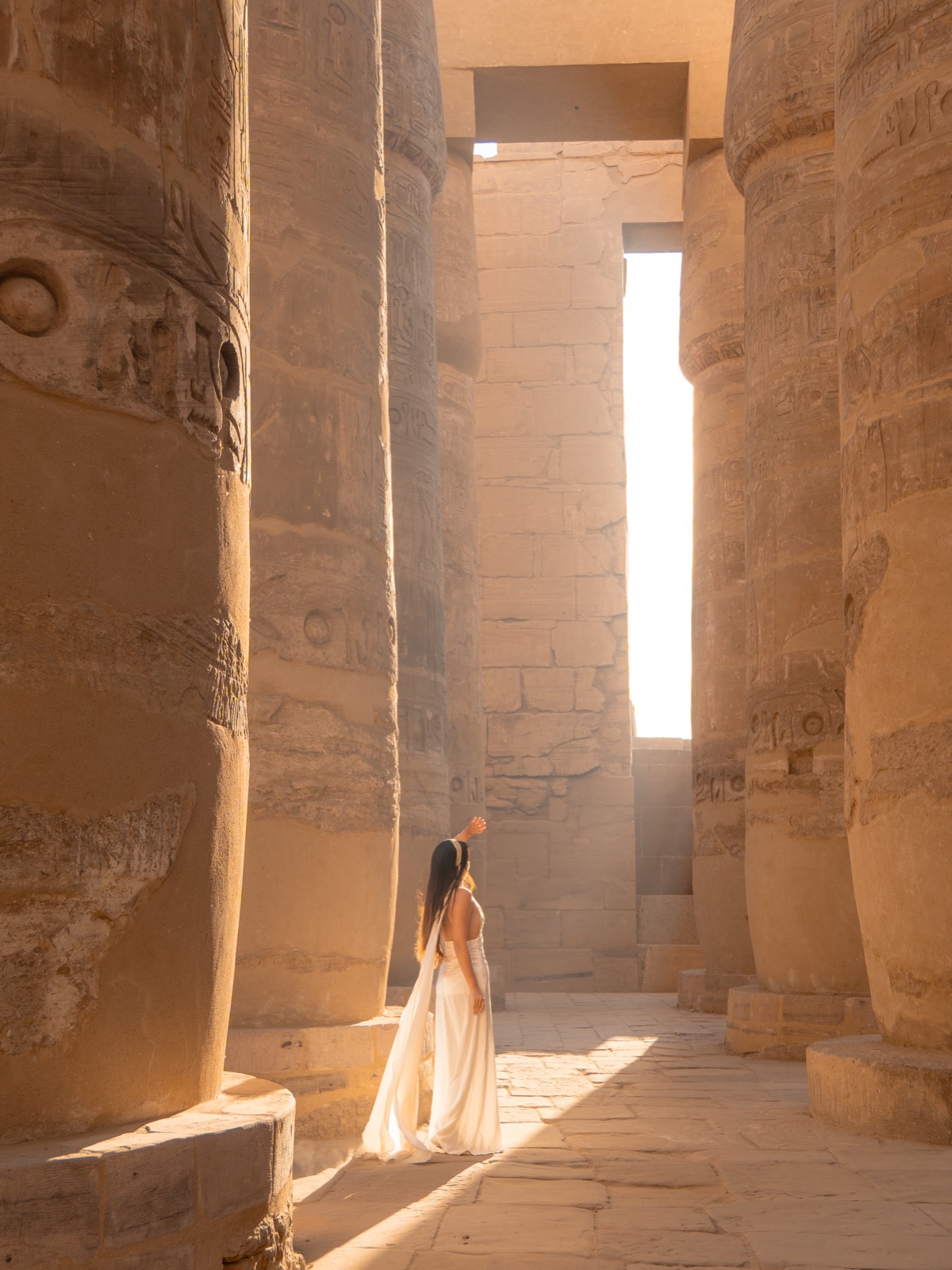 Woman standing between columns at Karnak Temple in Luxor