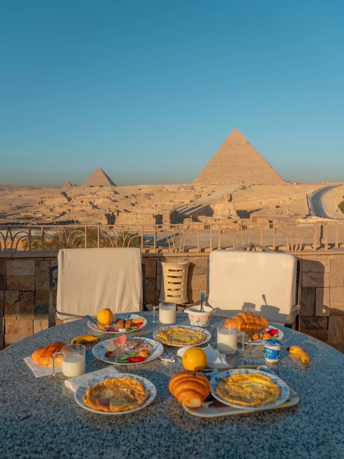Breakfast spread on the Guardian Guest House rooftop with the Pyramids of Giza behind it