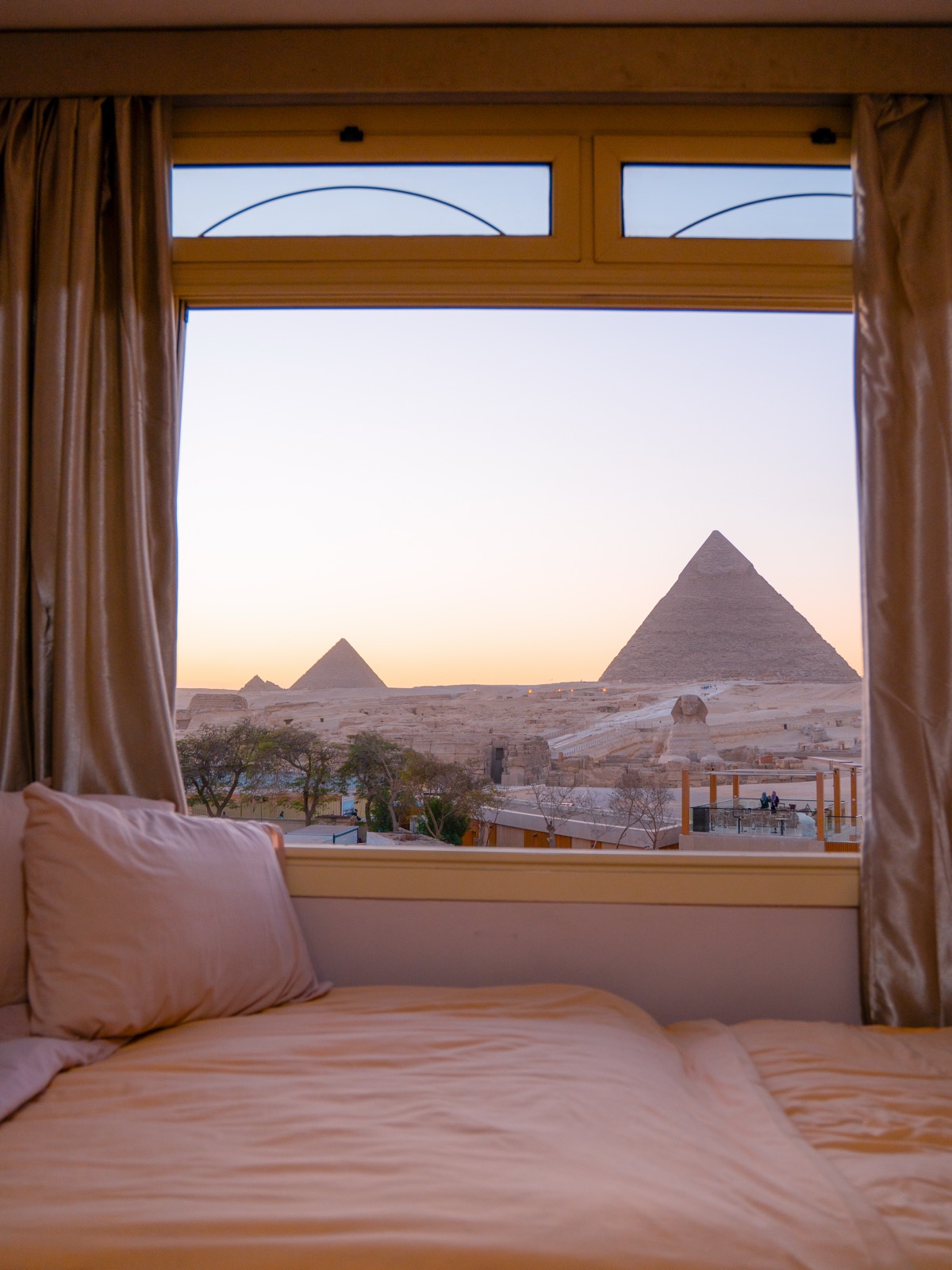Bed and window view of the Pyramids of Giza from Guardian Guest House