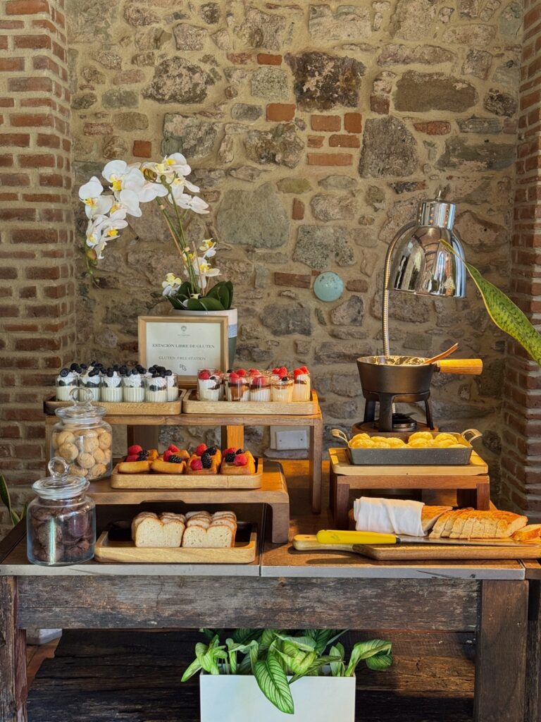 Beautiful breakfast buffet display with pastries, fruit tarts, and bread against the original stone walls of Hotel La Compañía in Casco Viejo, Panama