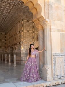 Woman in purple lehenga at the Sheesh Mahal mirror palace inside Amber Fort, Jaipur, India