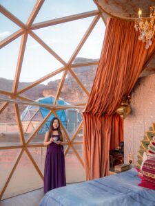 Woman inside a luxury geodesic glamping dome with desert views in Wadi Rum, Jordan