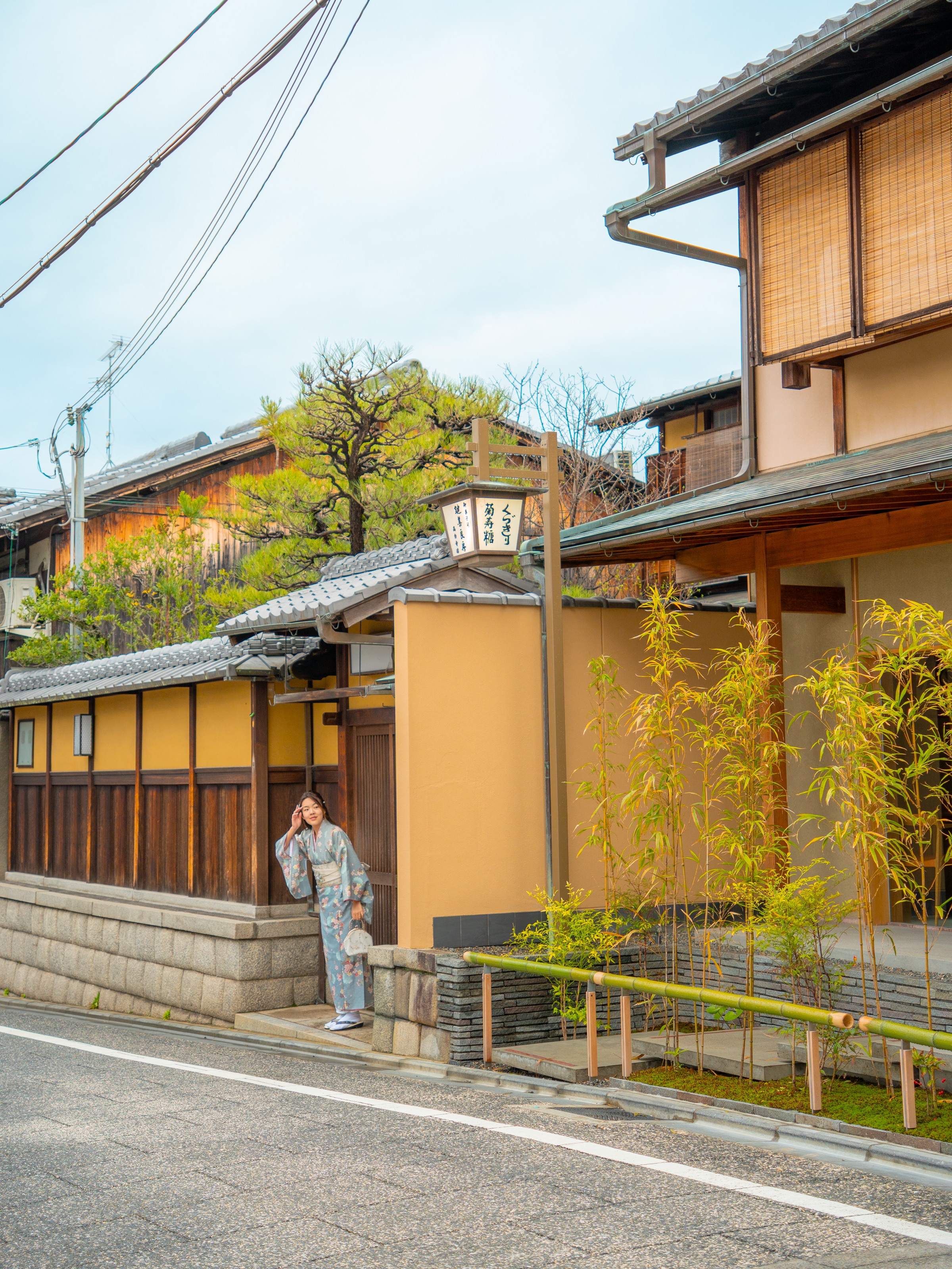 Woman in kimono on a traditional street in Kyoto Gion district with wooden machiya houses