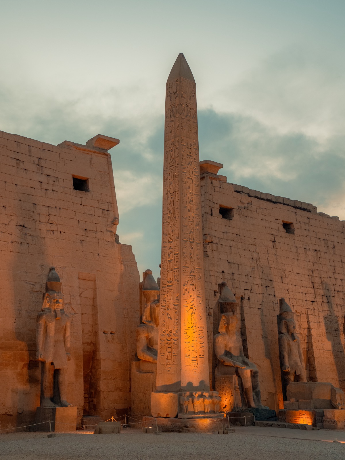 Lit obelisk and statues at Luxor Temple in Egypt